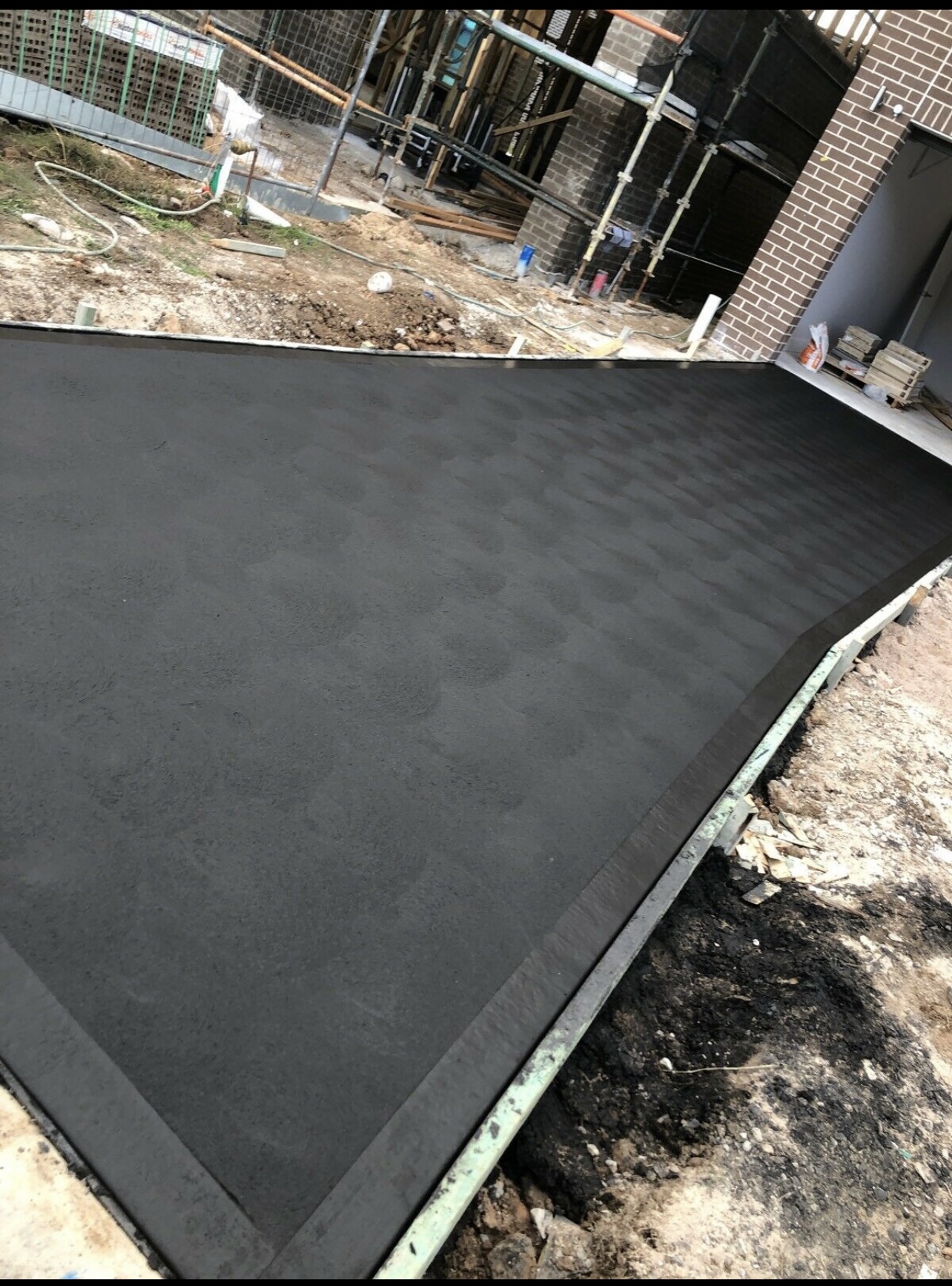 Freshly finished cove finish concrete driveway at a Sydney home
